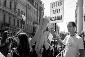 a man holding a sign in the middle of a crowd — Foto por Anastasiya Badun na Unsplash