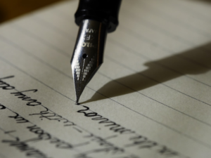 fountain pen on black lined paper — Foto por Aaron Burden na Unsplash