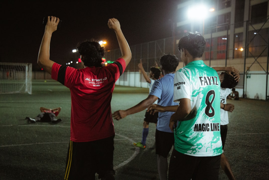 a group of people standing on top of a soccer field — Foto por Fahim mohammed jaseem na Unsplash