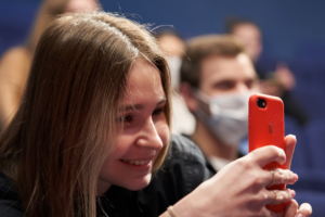 woman in black shirt holding red smartphone — Foto por Maxim Tolchinskiy na Unsplash
