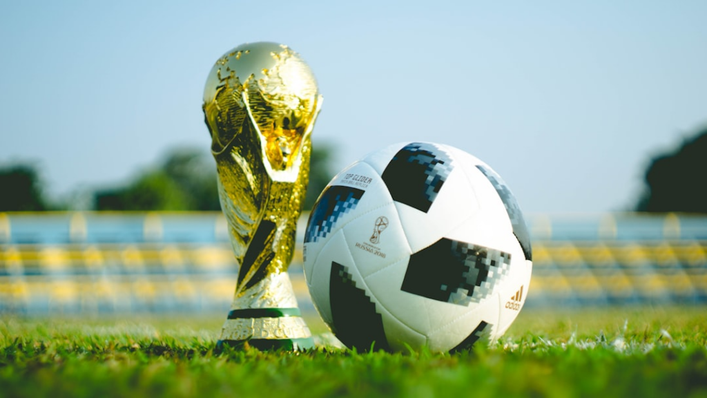 gold-colored trophy and soccerball — Foto por Fauzan Saari na Unsplash