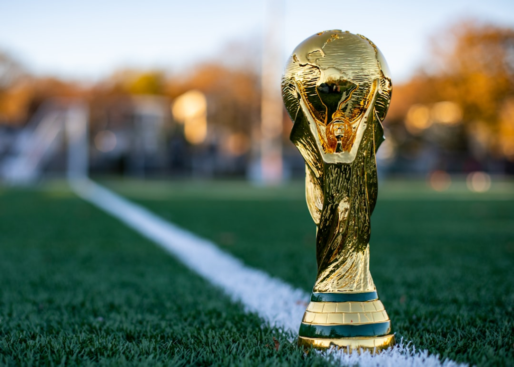 a golden trophy sitting on top of a lush green field — Foto por My Profit Tutor na Unsplash