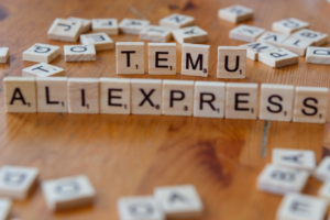 Scrabble tiles spelling the word temu allexpress on a wooden table — Foto por Markus Winkler na Unsplash