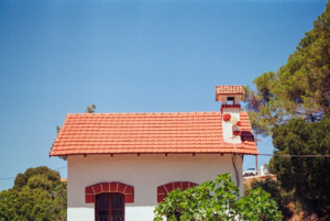 A small white house with a red roof — Foto por Artists Eyes na Unsplash