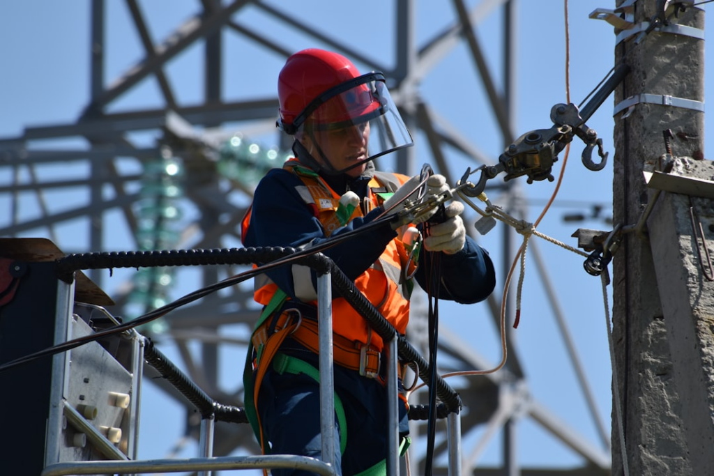 shallow focus photo of man fixing steel cable — Foto por Anton Dmitriev na Unsplash