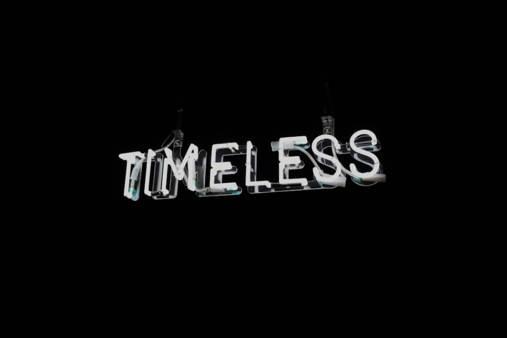 White neon word timeless on black background — Foto por Sinthujan Thangavelu na Unsplash