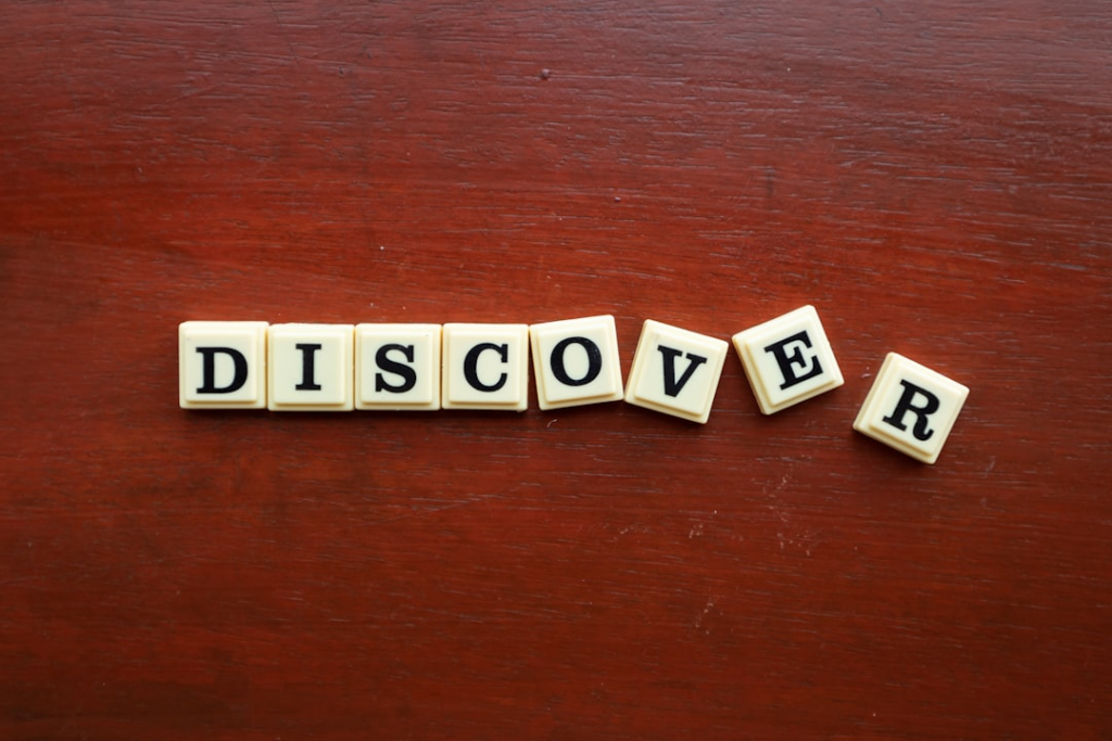 the word discovery spelled with scrabble letters on a wooden surface — Foto por Ling App na Unsplash