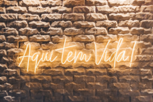 a brick wall with a neon sign on it — Foto por Antonino Visalli na Unsplash