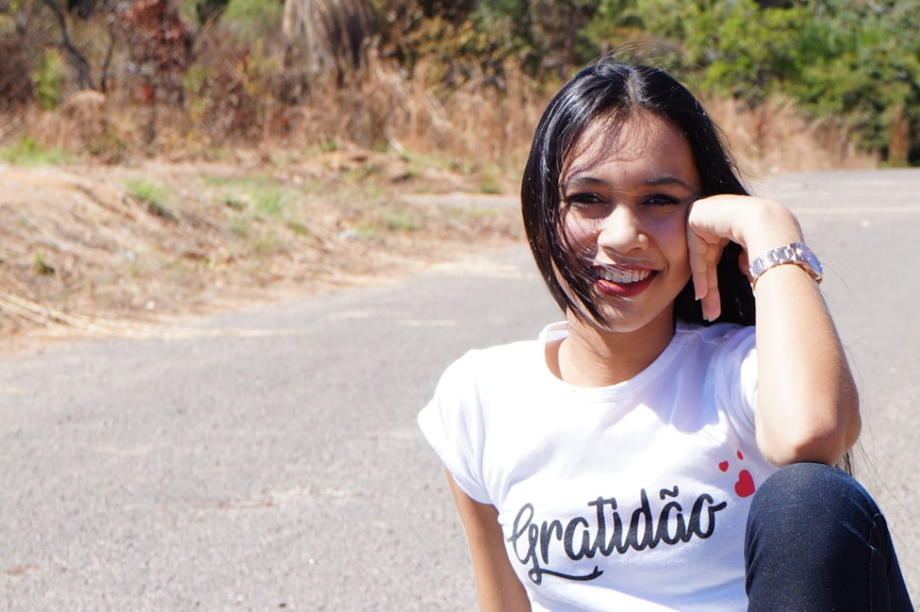 a young girl sitting on the side of a road — Foto por Gleive Marcio Rodrigues de Souza na Unsplash
