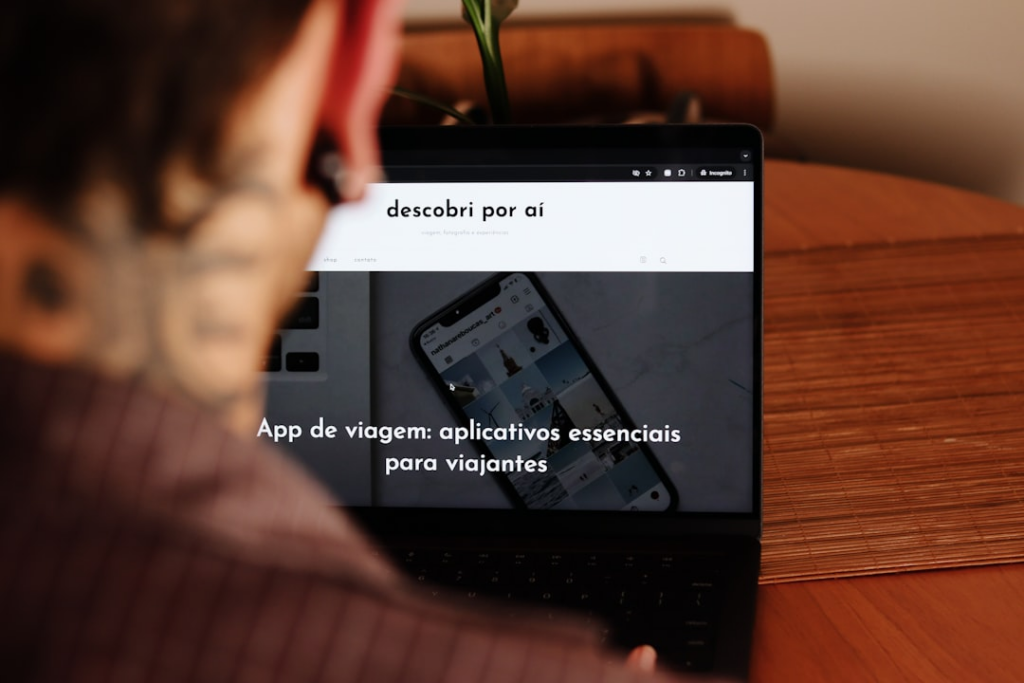 A person sitting at a table with a laptop — Foto por Nathana Rebouças na Unsplash
