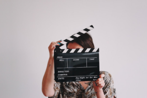 a woman holding a clapper over her face — Foto por Jon Tyson na Unsplash