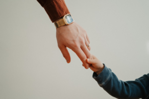 a person holding the hand of a child — Foto por Andrik Langfield na Unsplash