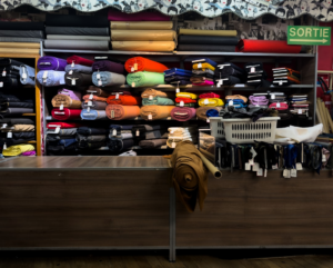 Rolls of colorful fabric displayed on shelves in a store. — Foto por Eddie Pipocas na Unsplash