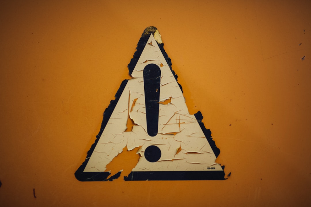 a triangle shaped sign on a yellow wall — Foto por Markus Spiske na Unsplash