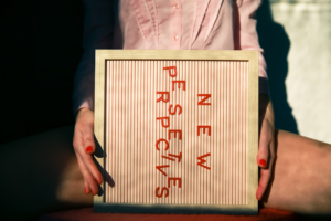 a person holding a sign that says never sustenance — Foto por Ava Sol na Unsplash